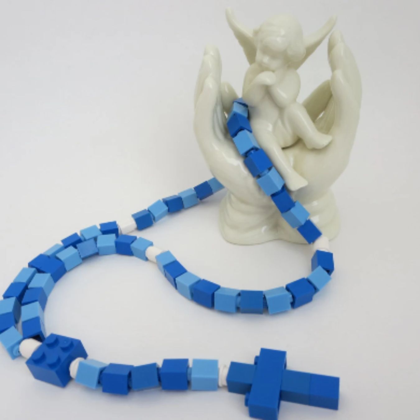 Child rosary made with Lego bricks in two shapes of blue.